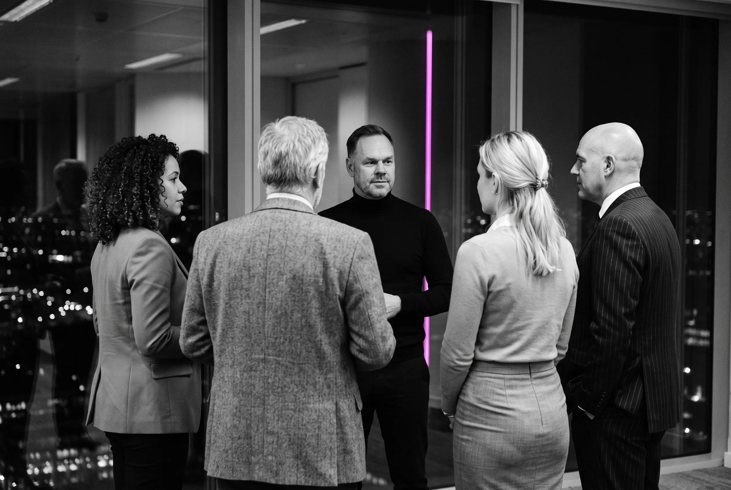 Helge Weiss in conversation with executives in dark suits at a skyscraper window at night, the others in silhouette, a magenta neon strip on the glass.